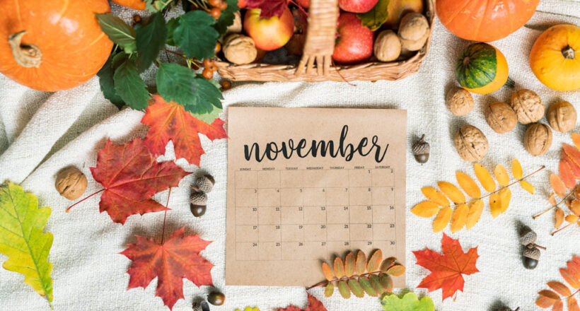 Top view of November calendar surrounded by harvest and autumn leaves